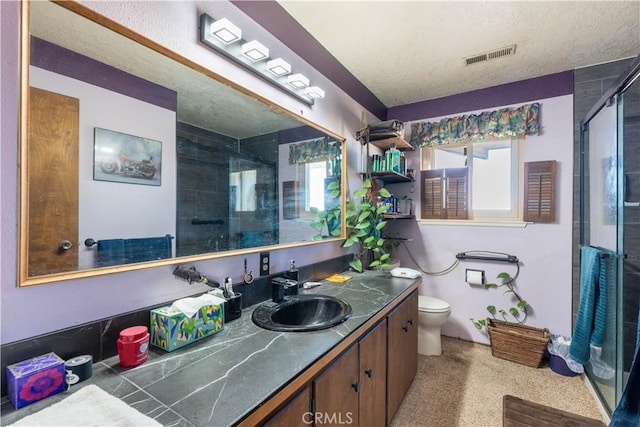 bathroom featuring toilet, an enclosed shower, a textured ceiling, and vanity