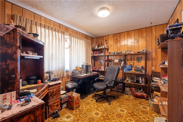 office space featuring a textured ceiling and wood walls