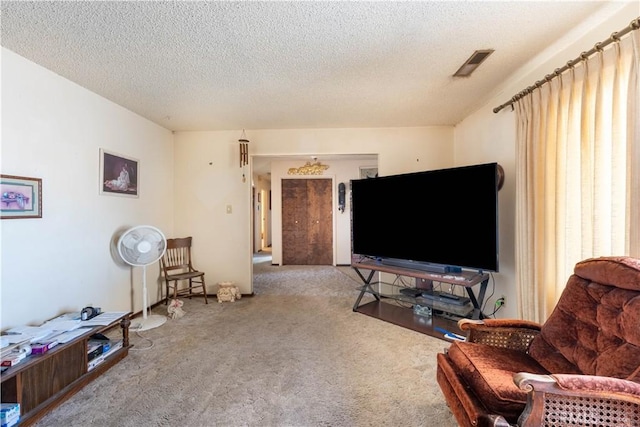 carpeted living room featuring a textured ceiling