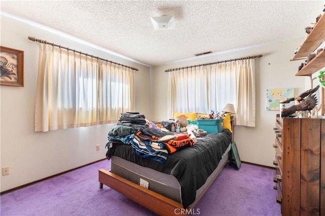 carpeted bedroom featuring a textured ceiling