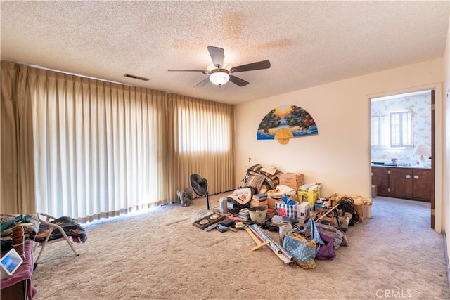 miscellaneous room featuring a textured ceiling, carpet floors, and ceiling fan