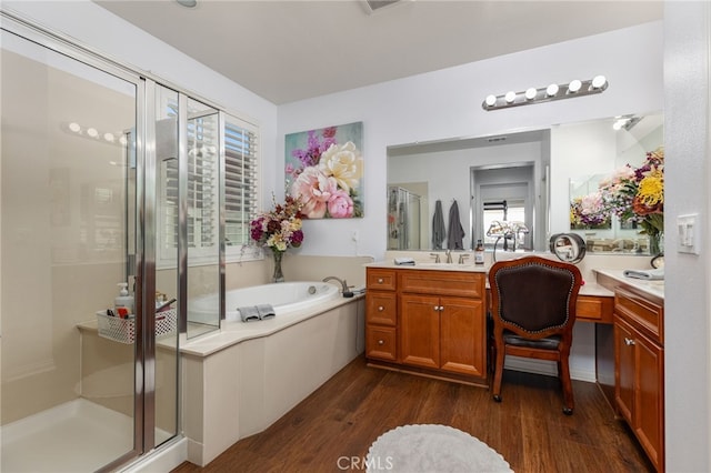 bathroom with hardwood / wood-style floors, vanity, and independent shower and bath