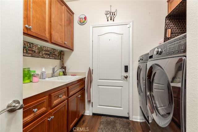 laundry area with cabinets, dark wood-type flooring, washer and dryer, and sink