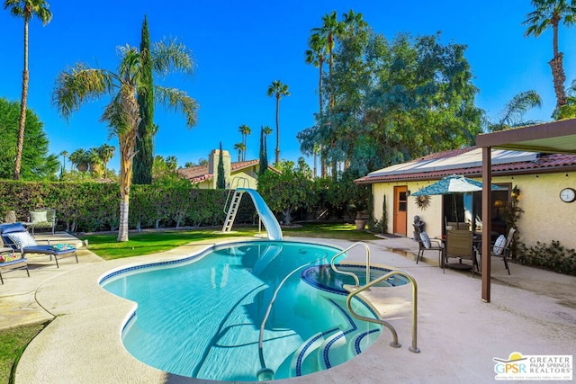 view of pool with a yard, a patio area, and a water slide