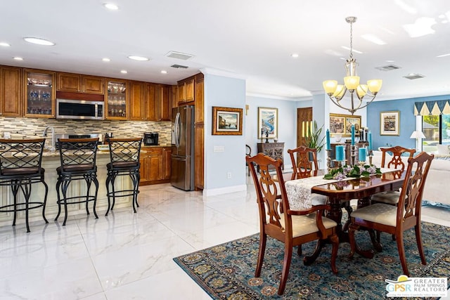 dining room with ornamental molding and a chandelier