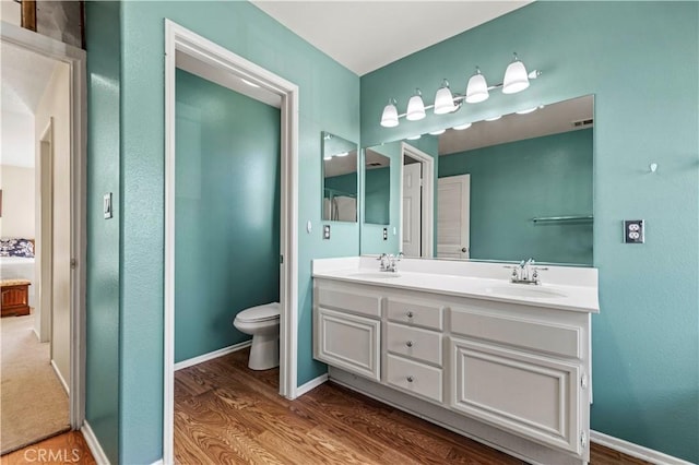 bathroom featuring vanity, hardwood / wood-style flooring, and toilet