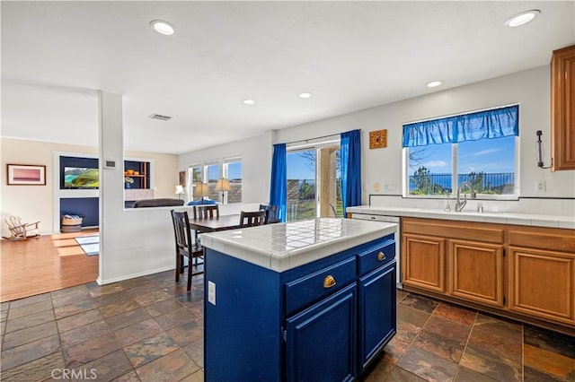 kitchen with a center island, tile counters, and sink