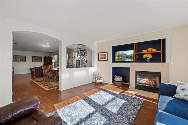 living room with ceiling fan, a fireplace, and hardwood / wood-style flooring