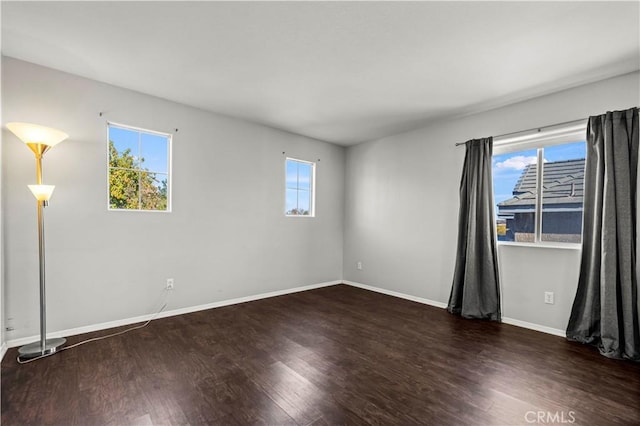 spare room featuring dark wood-type flooring and a wealth of natural light