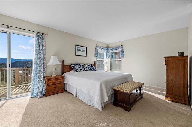 bedroom featuring a mountain view, light carpet, and access to outside