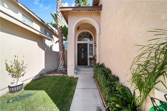 entrance to property featuring a lawn