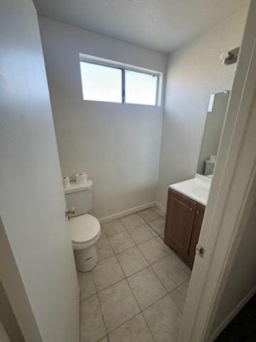 bathroom with tile patterned flooring, vanity, and toilet