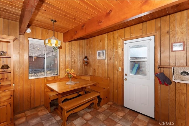 dining room featuring wood walls, wooden ceiling, and beam ceiling