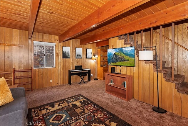 living room featuring beam ceiling, wood walls, and carpet floors