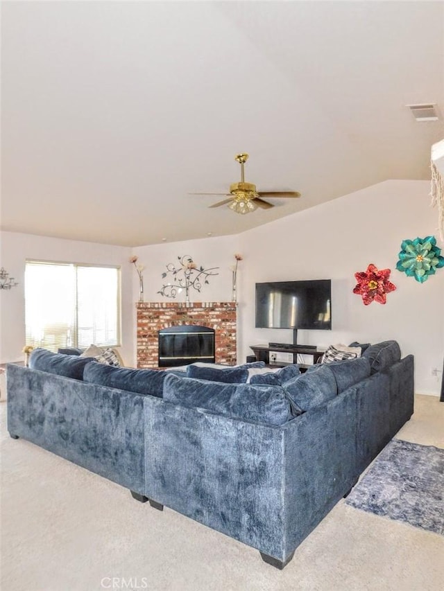 living room with lofted ceiling, a fireplace, ceiling fan, and carpet flooring