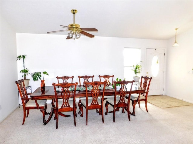 carpeted dining space with vaulted ceiling and ceiling fan