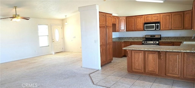 kitchen with stainless steel appliances, vaulted ceiling, sink, and ceiling fan