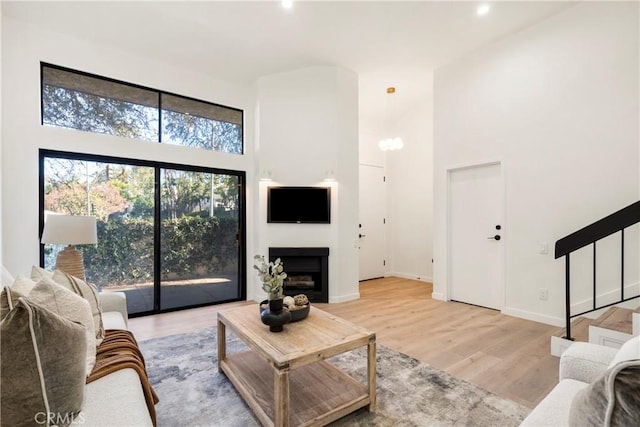 living room featuring light hardwood / wood-style flooring and a high ceiling