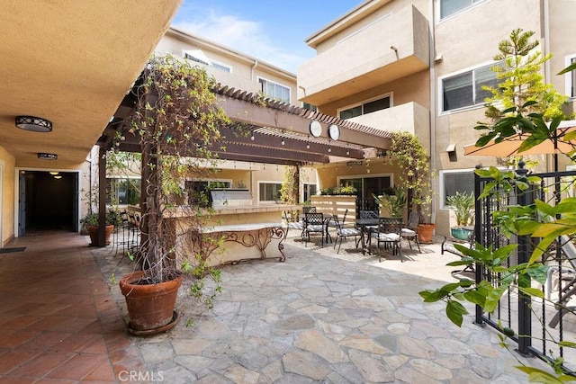 view of patio featuring outdoor dining area, an outdoor bar, and a pergola