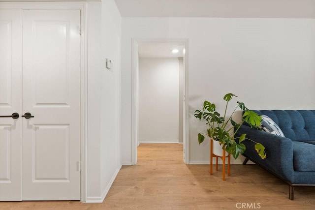 hallway with light wood-style flooring and baseboards