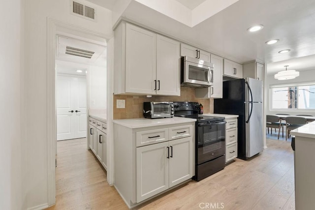 kitchen featuring white cabinetry, visible vents, appliances with stainless steel finishes, and light countertops