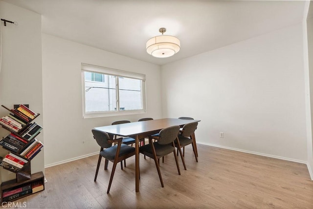 dining room featuring light wood-style flooring and baseboards