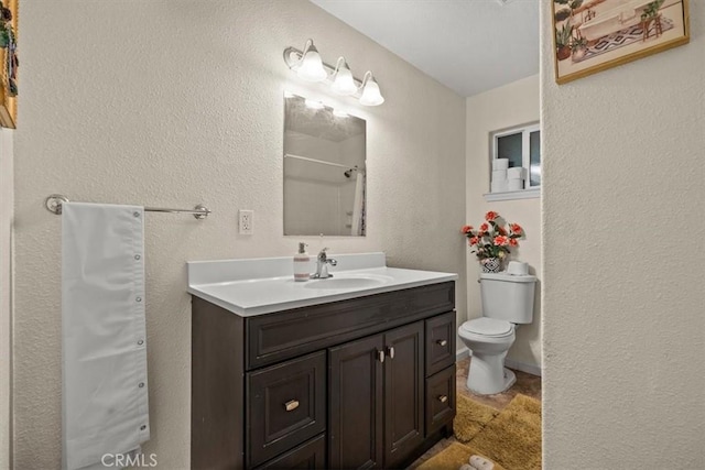 bathroom with vanity, toilet, and a shower