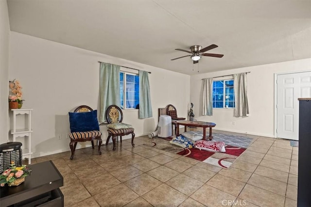 living area featuring tile patterned floors and ceiling fan