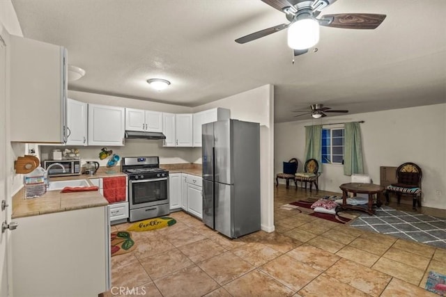 kitchen with white cabinets, ceiling fan, sink, and stainless steel appliances