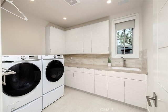 washroom with washer and dryer, cabinet space, a sink, recessed lighting, and visible vents