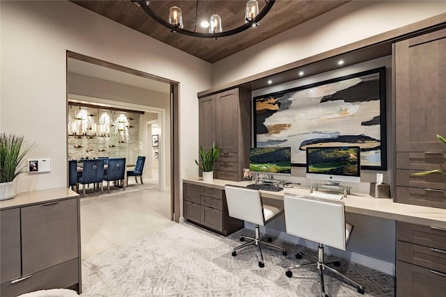 office area with a notable chandelier, wooden ceiling, and built in study area