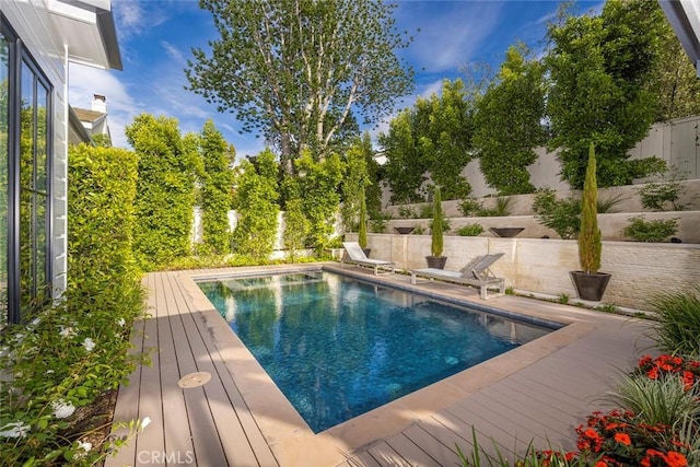 view of pool with a fenced in pool, a fenced backyard, and a wooden deck