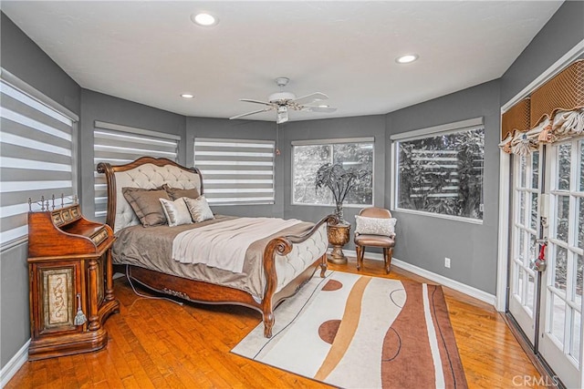 bedroom with hardwood / wood-style flooring, ceiling fan, and multiple windows