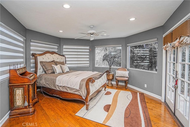 bedroom featuring baseboards, multiple windows, wood-type flooring, and recessed lighting