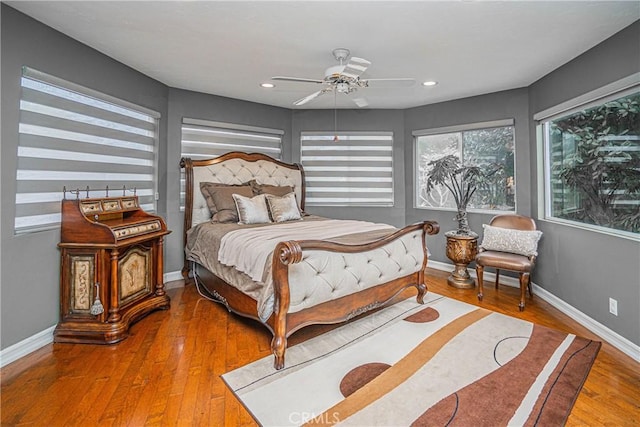 bedroom featuring ceiling fan, recessed lighting, wood finished floors, and baseboards