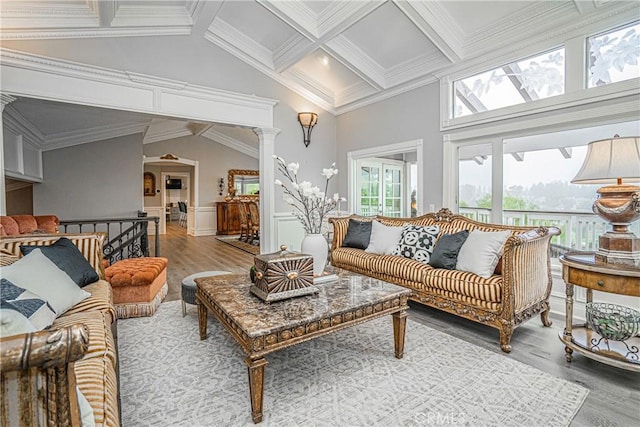 living area featuring ornamental molding, wood finished floors, beam ceiling, and ornate columns