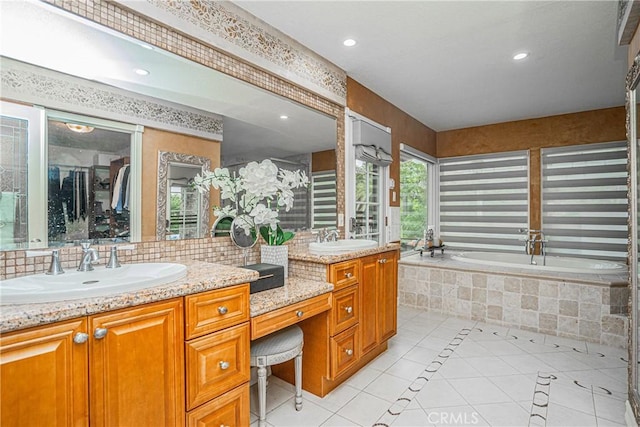 full bath featuring double vanity, tile patterned flooring, a sink, and a bath