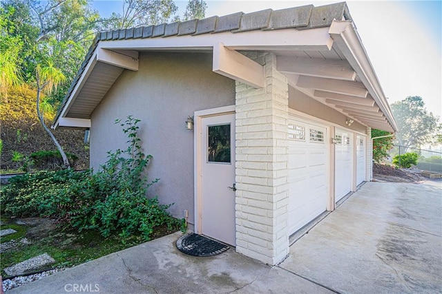 view of side of home featuring a garage and stucco siding