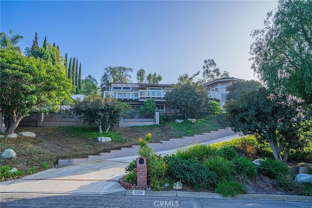 view of front of home featuring fence and a balcony