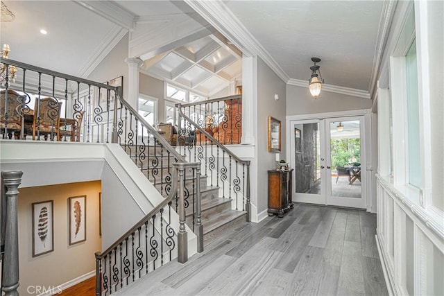 entryway with ornate columns, wood-type flooring, vaulted ceiling with beams, crown molding, and french doors