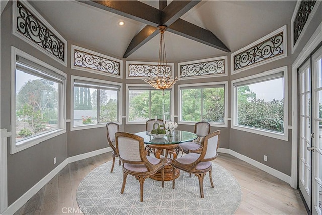 dining area featuring light wood-style floors, plenty of natural light, baseboards, and vaulted ceiling