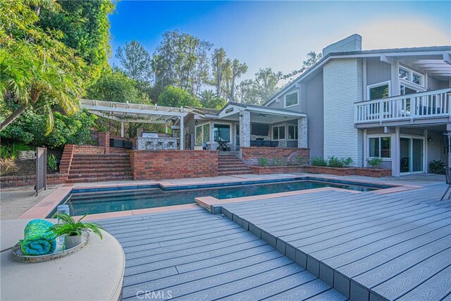 view of pool with an outdoor kitchen and a pergola