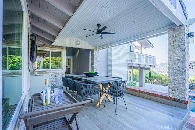 view of patio featuring a ceiling fan, outdoor dining area, a sink, and a balcony