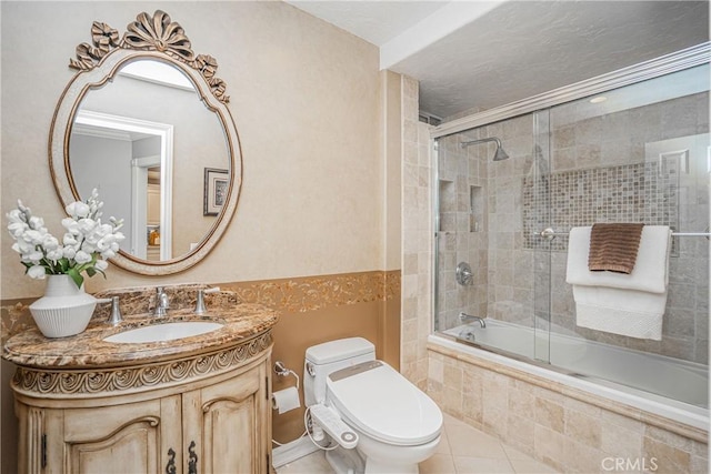 full bath with toilet, tile patterned flooring, tiled shower / bath, and vanity