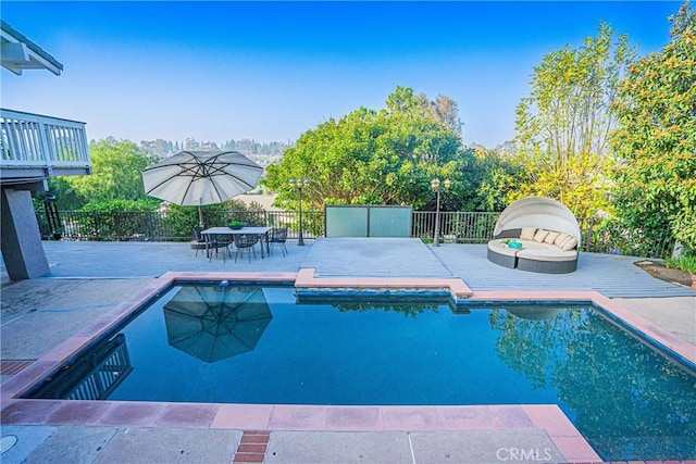 view of pool with outdoor dining area, a patio area, fence, and a fenced in pool