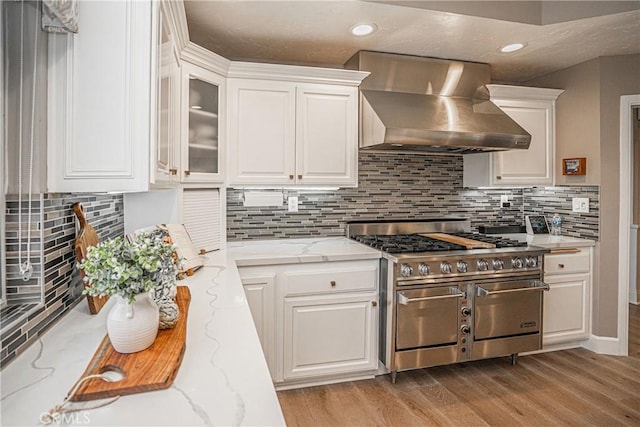 kitchen featuring range with two ovens, extractor fan, glass insert cabinets, and white cabinets