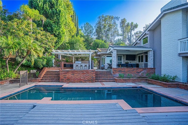 view of swimming pool with a bar, stairway, a pergola, and a patio