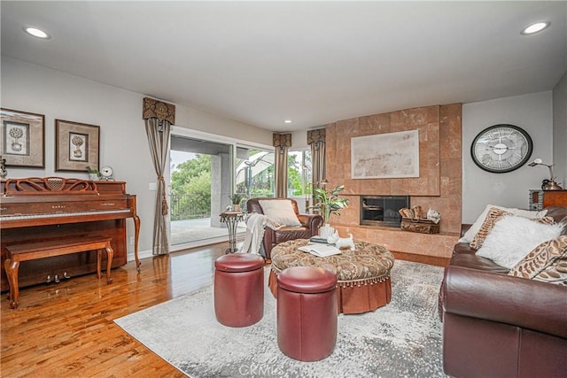 living room featuring a fireplace, wood finished floors, and recessed lighting