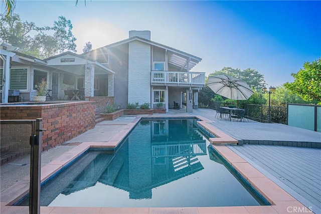 view of pool featuring a patio, exterior bar, a wooden deck, and a fenced in pool