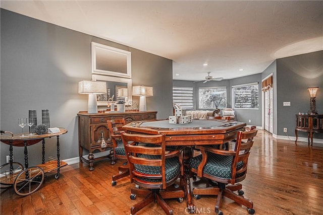 dining space featuring ceiling fan, hardwood / wood-style flooring, and baseboards